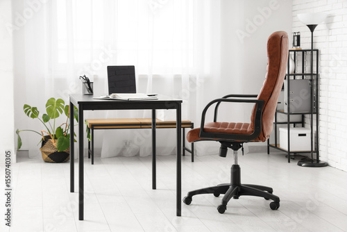 Interior of modern office with workplace, lamp and shelf unit