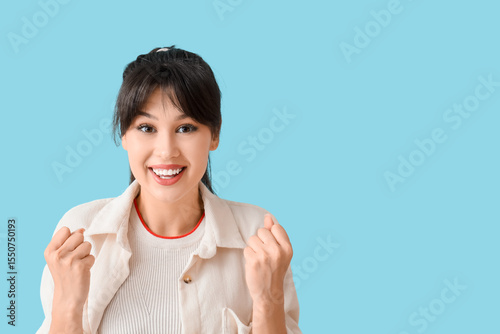 Smiling young woman on blue...