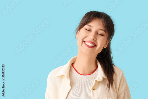 Smiling young woman on blue...
