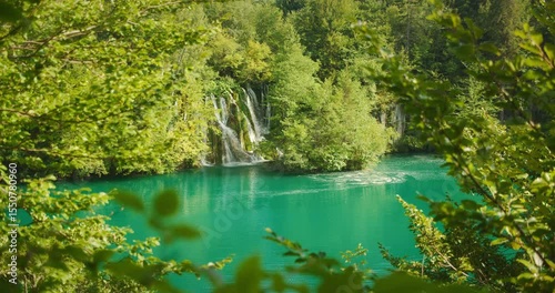 Wallpaper Mural Waterfall emerging from dense green foliage into calm turquoise lake in Croatia Torontodigital.ca