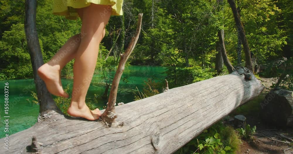 custom made wallpaper toronto digitalBarefoot woman balances on a log above turquoise water in Plitvice Lakes National Park