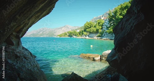 Wallpaper Mural View from a rocky cave opening toward turquoise sea and coastal town in Croatia Torontodigital.ca