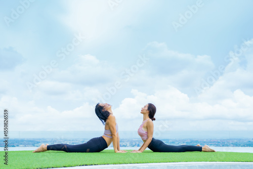 yoga, Asian woman wearing yoga clothes practicing yoga, Asia group of women exercising healthy lifestyle in outdoor fitness studio. swimming pool. Sport activity, gymnastics or ballet dancing class.