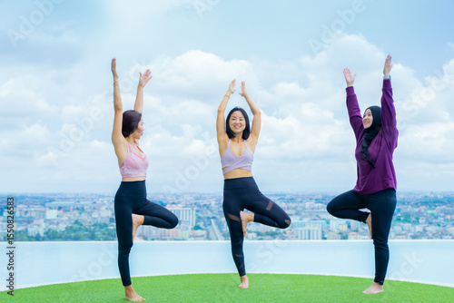 yoga, Asian woman wearing yoga clothes practicing yoga, Asia group of women exercising healthy lifestyle in outdoor fitness studio. swimming pool. Sport activity, gymnastics or ballet dancing class.