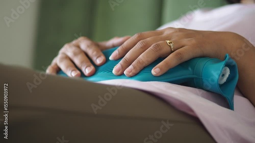 Relaxing on sofa with heating pad for discomfort relief
