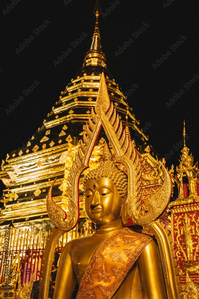 Fototapeta premium Golden Buddha statue illuminated at night in Wat Phra That Doi Suthep, Chiang Mai