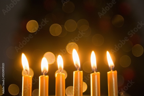 Close-up of lit candles in a row burning