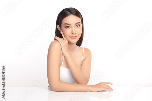 A beautiful young Asian woman with clean, fresh skin against a white background. Skincare, facial treatment, cosmetology, beauty, and spa. An elegant portrait of an Asian woman.