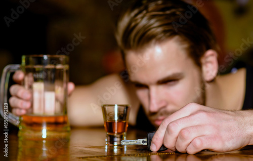 Drunk driver with car key. Alcohol problem. Lonely man drinking before driving vehicle. Drunk driver man with glass of alcohol. Hopeless alcoholic driver.