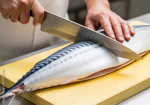 A chef cut a big piece of mackerel fillet on a wooden cutting board	