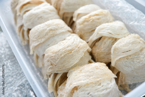 Close-up of premium dried edible bird's nests neatly arranged in a clear plastic box. A luxurious delicacy prized for its health benefits in traditional Asian cuisine.