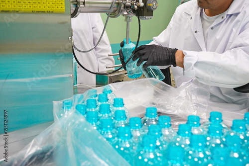An employee checks liquid cosmetics at the factory.