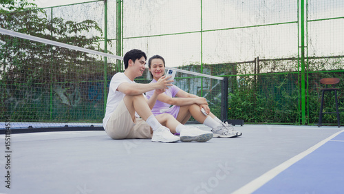 Couple enjoying moments on a pickleball court while discussing strategies in the late afternoon