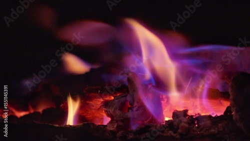 Close-up of a campfire with glowing coals at night. Video with sound.