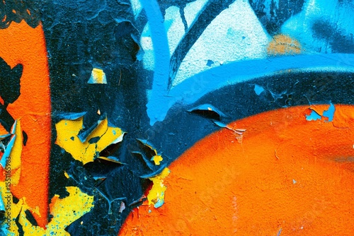 Abstract texture with vibrant blue, orange, yellow hues reminiscent of 80s graffiti art. Distressed, peeling paint surface, textured look. Posters, backgrounds, digital art, retro 80s, modern visuals