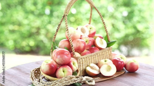 Shine Nectarine in basket on wooden table in garden, Shine Nectarine with leaves on blur background.
