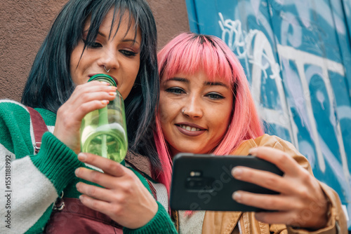 Fun urban women taking a selfie or live video on the street