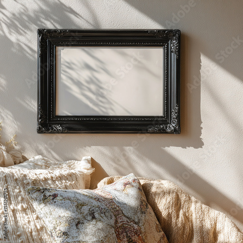 Black ornate frame on beige wall with beige throw pillows