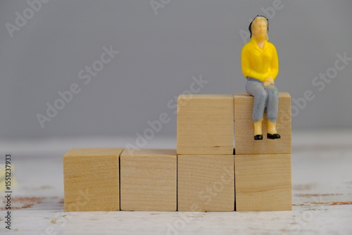 wooden blocks scattered on the wooden table with wooden figures as a people concept. 