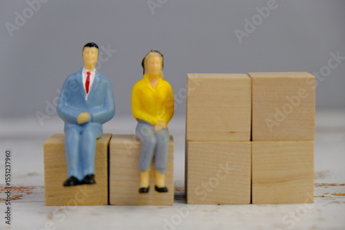 wooden blocks scattered on the wooden table with wooden figures as a people concept. 