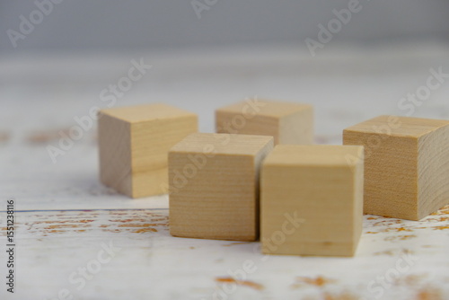 wooden blocks scattered on the wooden table with wooden figures as a people concept. 