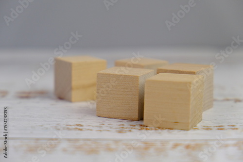 wooden blocks scattered on the wooden table with wooden figures as a people concept. 