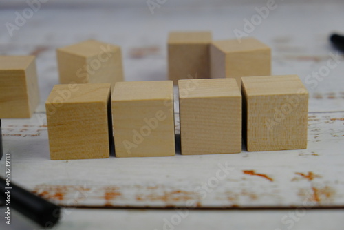 wooden blocks scattered on the wooden table with wooden figures as a people concept. 