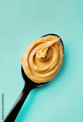 Peanut butter swirl on spoon against teal background