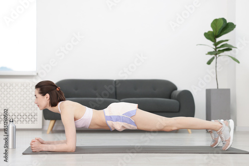 Woman doing plank exercise at home. Sport and healthy lifestyle