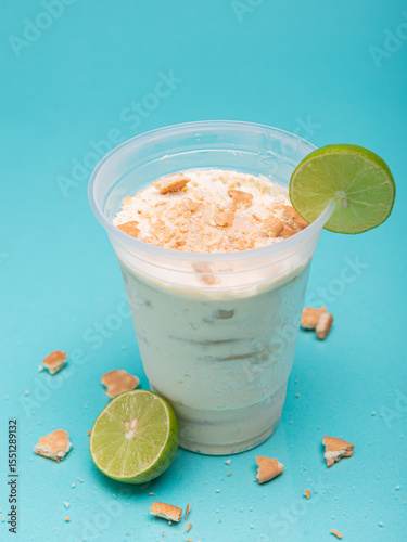 Lemon charlotte in plastic cup on light blue background photo