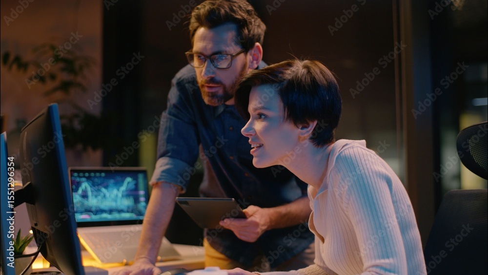 Obraz premium Business man woman cooperation in night office trader broker working computer stock market analysis bitcoin trading online crypto currency businessman businesswoman co-workers teamwork mentor intern