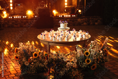 Wedding cake and cupcakes on the table