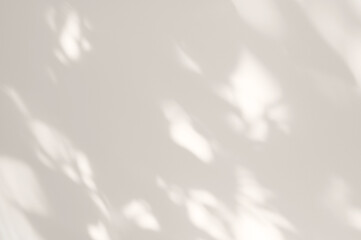 Soft abstract spotty sunlight shadows on neutral light beige plaster wall background, minimal aesthetic backdrop for business branding and social media design