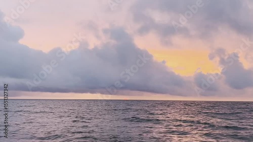 Seaside Sunset with Clouds and Calm Waves