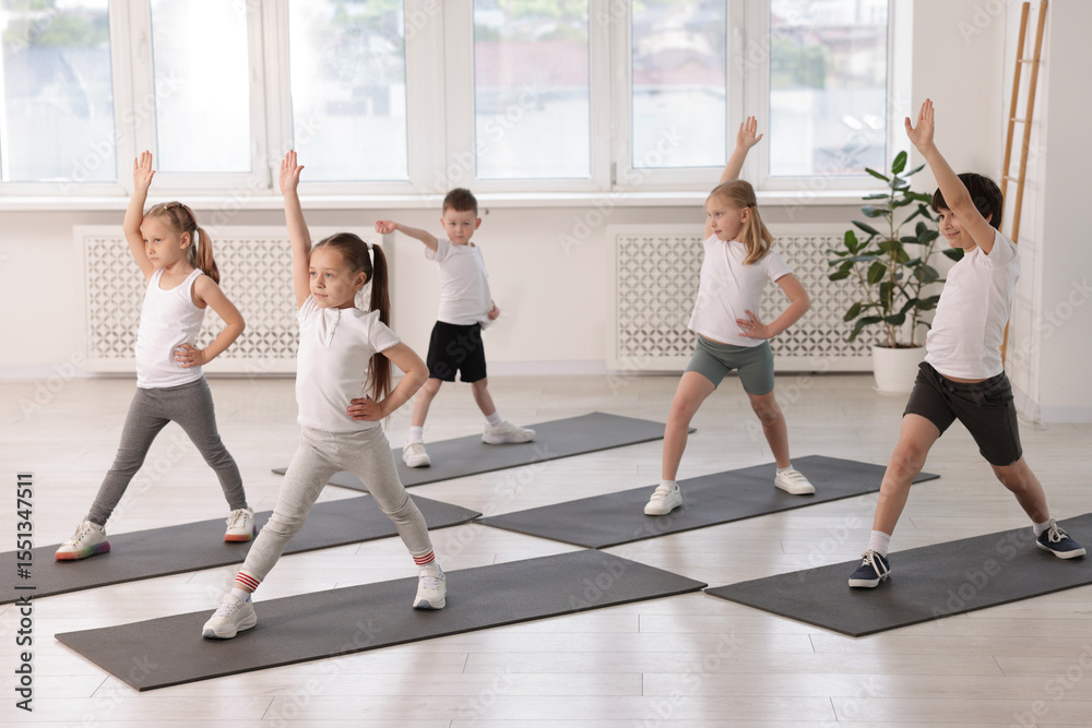 Obraz premium Group of children practicing yoga on mats in class