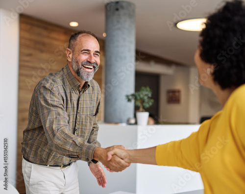 Group of  businesspeople having a meeting shaking hands handshake introducing each other and applauding during meeting in the office. Teamwork and success concept, portrait of a middle aged mature bus