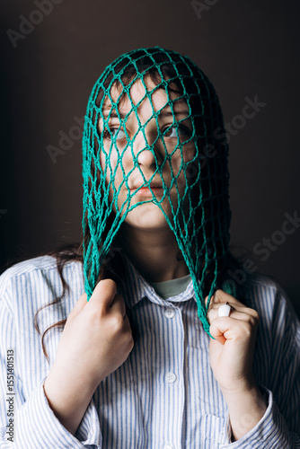 Portrait of young woman with mesh bag on head, eco lifestyle and sustainability.