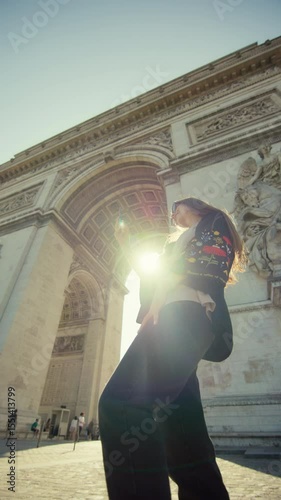 Arc de Triomphe Paris girl tourist taking photo. Beautiful woman taking photo near historical monument in capital of France, traveling in Europe.