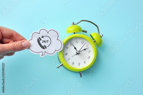 Inscription: 24/7 and an alarm clock nearby, a concept of 24/7 assistance, services, and actions