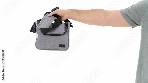 Hand holding a gray shoulder bag with strap
