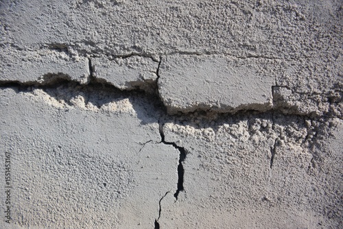 Gray concrete wall with deep cracks
