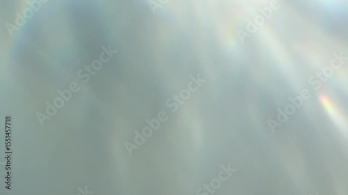 Soft abstract light reflections with iridescent highlights. Gentle pastel gradients and dreamy motion suggest a holographic or surreal atmosphere.