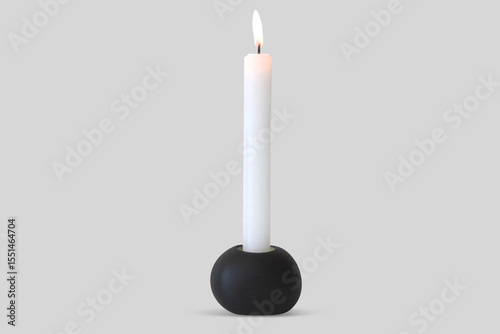 Single candle in candleholder near grey wall