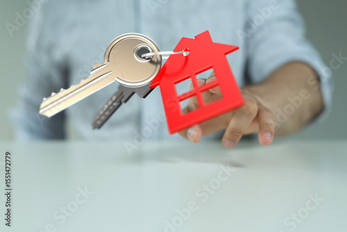 Image of house keys and a red house model, representing homeownership and real estate.