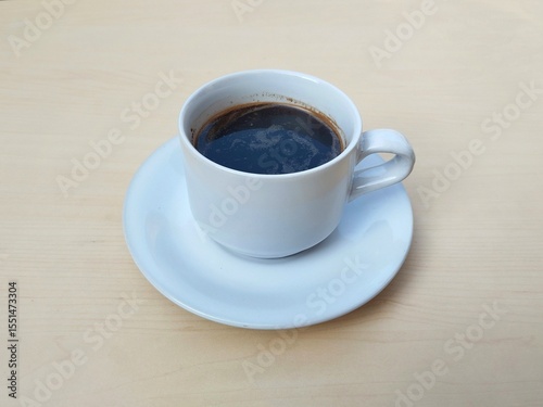 Black coffe in white glass on wooden table background 