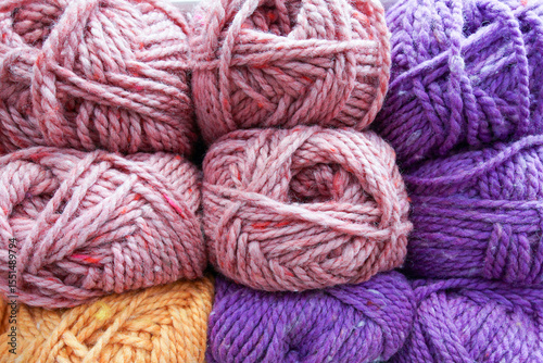 Shelf in a store with multi-colored skeins of yarn. Collection of balls of wool yarn. Close-up.