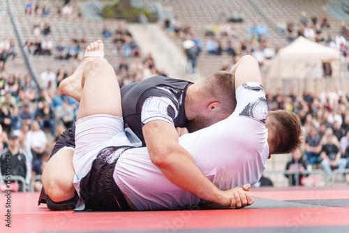 Φωτογραφία Two athletes competing in no-gi Brazilian jiu-jitsu BJJ match on outdoor mat