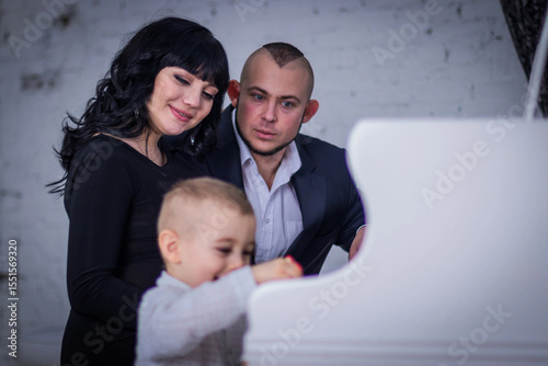 the child plays the piano for mom and dad