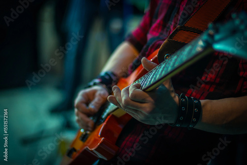 The man plays the guitar, close-up of the fingers on the strings.