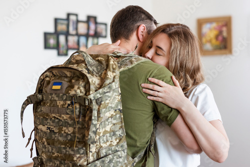 Soldier saying Goodbye Hugging his Wife at Home. Sad Woman say farewells  to her Military Husband. Husband is back from the Army.  